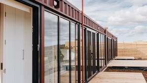 En modern byggnad med stora glasfönster och en träveranda.