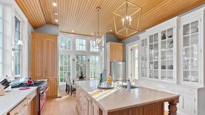 A spacious kitchen with wooden cabinets, a large island, and a built-in refrigerator. - Unwind in Ultimate Luxury: Ridgeview Manor, Boone's Mountain Masterpiece (Boone)