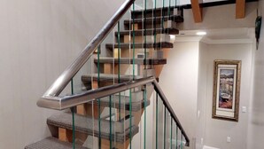 Eine Treppe mit Glasgeländern und Holzstufen.