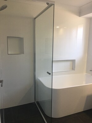 Bathtub, hair dryer, towels, toilet paper