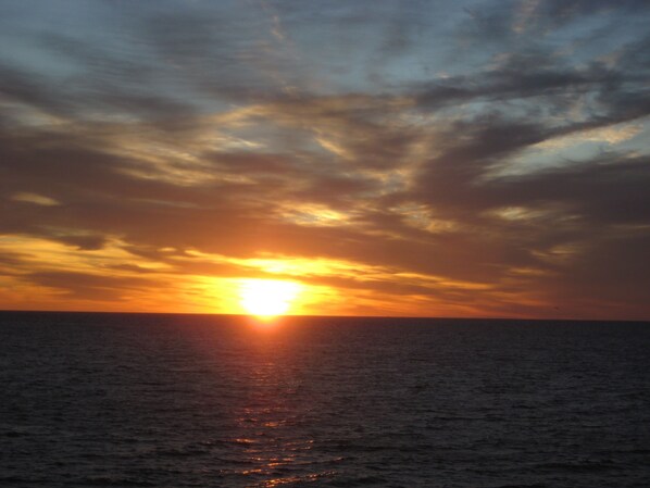 Un atardecer sobre el océano con horizonte despejado.
