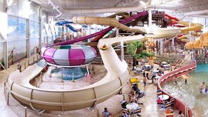Ein großer, überdachter Wasserpark mit zahlreichen Rutschen und Becken.