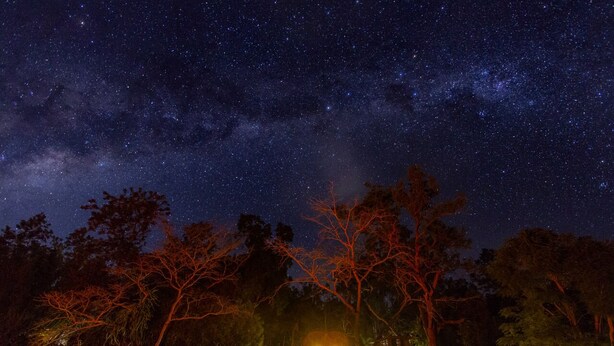 Una casa con un porche iluminado bajo un cielo estrellado.
