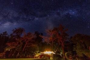 Una casa con un porche iluminado bajo un cielo estrellado.