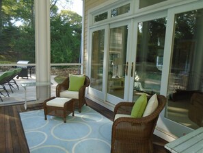 Relax outdoors with a patio featuring a grill, wicker chairs, and a small table.