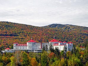 A large, multi-story hotel with red roofs, surrounded by autumn-colored trees and hills. - Affordable Luxury! 4per. Efficiency Ski-out  Condo at Bretton Woods (Caroll)