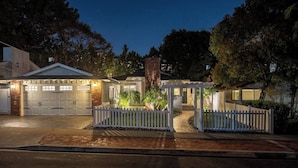 Un immobile residenziale con garage, un portico coperto e un recinto di legno bianco.