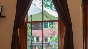 A room with a large window, a chair, a trash can, and a rug. - Beautiful Home in Historic Neighborhood
1/2 mile to Downtown and the Riverwalk (san antonio)