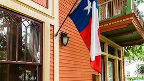 A building with a porch, a Texas flag, and two rocking chairs. - Beautiful Home in Historic Neighborhood
1/2 mile to Downtown and the Riverwalk (san antonio)