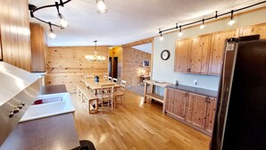 Una cocina moderna con armarios de madera, comedor y refrigerador.