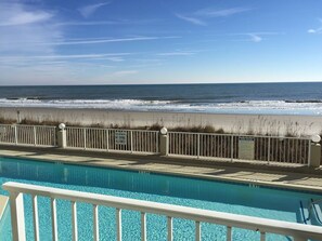 A pool with a view of the ocean and beach.