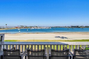 A beach view with a marina, chairs, and a clear sky.