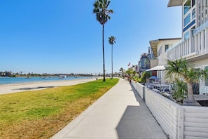 A beachfront hotel with a sidewalk, palm trees, and a view of the beach and ocean. - Beautiful Bayfront views! Townhome for family fun (San Diego)