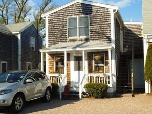 A two-story house with a front porch, a garage, and a driveway. - Two bedroom condo near to everything Ptown has to offer (Provincetown)