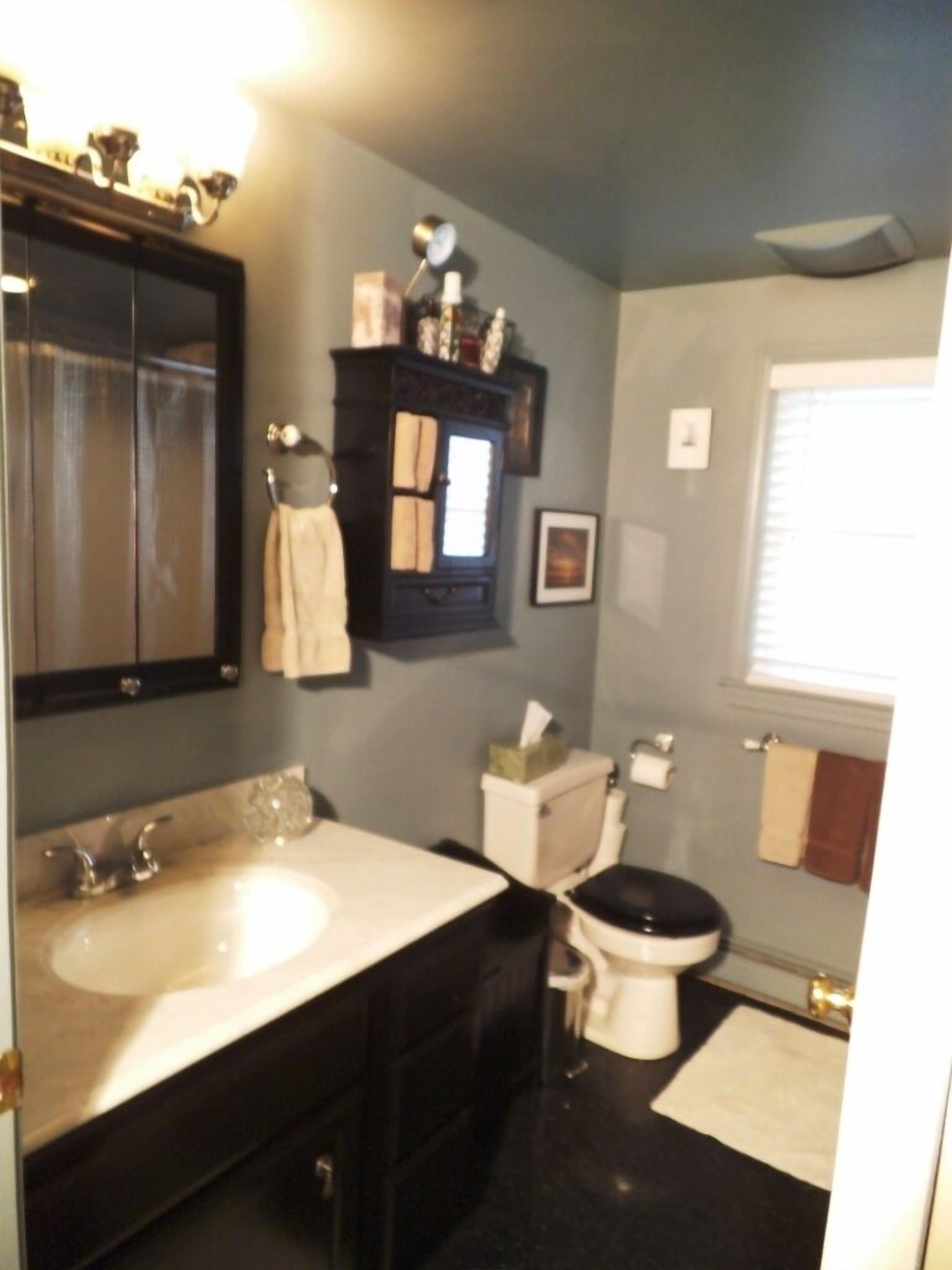 A bathroom with a double sink, a toilet, and a mirror.