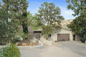 Un quartier résidentiel doté d’un garage, d’une allée et d’un jardin aménagé avec des arbres.