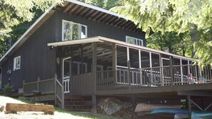 Un grand bâtiment en bois doté d’un porche abrité et d’une petite terrasse.