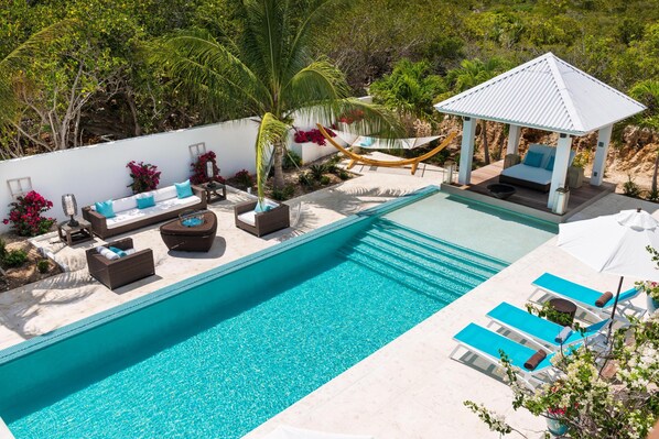 A heated pool, sun loungers