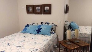 Een slaapkamer met een bed, twee nachtkastjes en een spiegel.