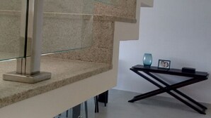 Un escalier moderne avec des rampes en verre et un motif géométrique.