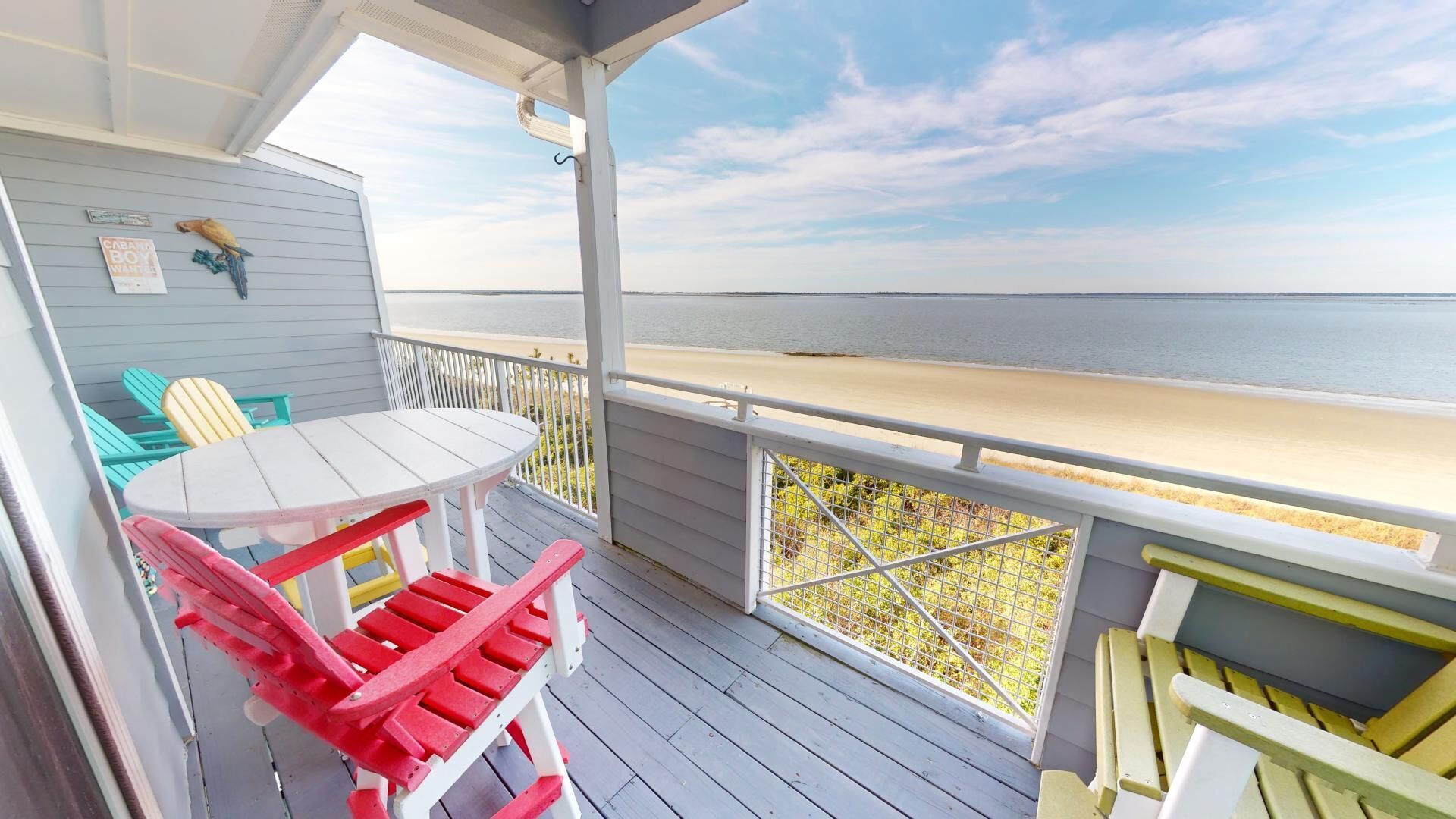 Una terraza techada con mesa y sillas, con vista a la playa.