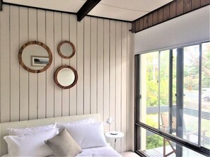 Relax in a serene space with a large bed, bedside table, and stunning outdoor views.