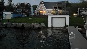 Une maison avec un garage, un quai et un étang.