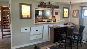 Une cuisine avec un coin bar, des meubles en bois et un ventilateur de plafond.