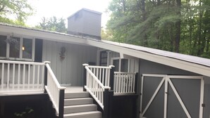 A house with a front porch, a staircase leading to the entrance, and a garage. - Location! Walk to Cranmore and Town! (Conway)