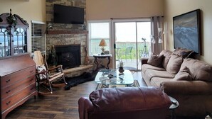 Ein Wohnzimmer mit Kamin, einer Couch, einem Couchtisch und einem Fernseher.