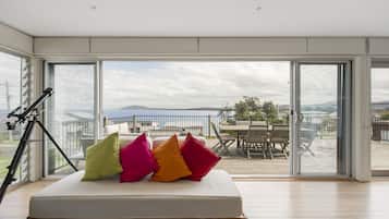 A room with a large sliding glass door leading to an outdoor deck with a table and chairs.