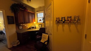 A kitchen with wooden cabinets, a microwave, and a chair. There is a window with a view of a tree outside. -  Savannah Suite  (Kennesaw)