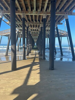 A pier structure with a wooden deck and metal supports extending into the water.
