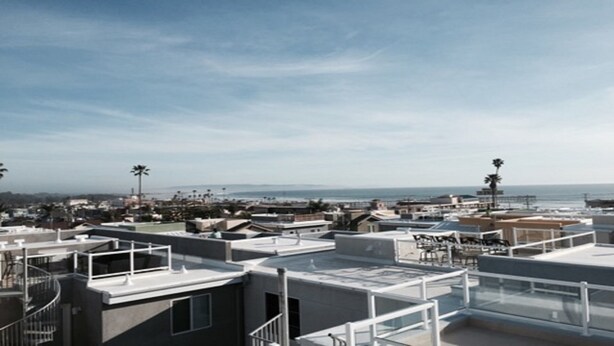 Eine Dachterrasse mit freiem Blick auf das Meer und die Stadt.