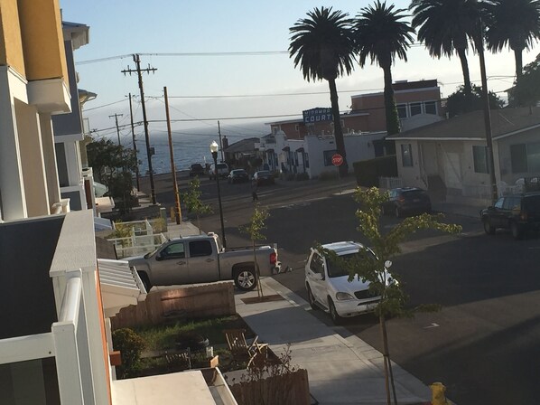A residential street with parked cars, a stop sign, and a building labeled 'MIDORO COURT'.