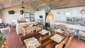 A dining area with a wooden table set for four, surrounded by wicker chairs. - Tree House Atmosphere on Chalk Sound National Park (Providenciales)