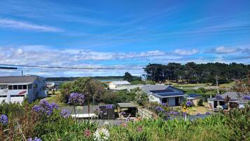 A residential area with houses, a solar panel on one roof, and a view of a natural landscape in the background.