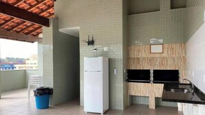 Una cucina compatta con frigorifero, lavello e pannelli decorativi in piastrelle.