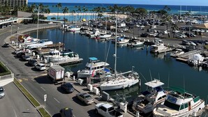 A marina with boats, a hotel, and a beach in the background. - New Decor! Oceanfront, Yacht Harbor, Luxury, Friday Fireworks front row, FAB! (Honolulu)