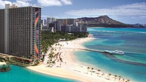 A beachfront hotel with a large building, a beach, and a mountain in the background. - New Decor! Oceanfront, Yacht Harbor, Luxury, Friday Fireworks front row, FAB! (Honolulu)