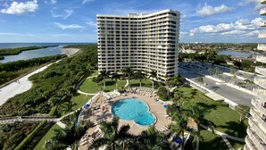 A high-rise hotel with a pool and a view of the ocean. - Newly Renovated Beach Condo with 2 Kings...Awesome Pool, Beach and Sunset Views (Marco Island)