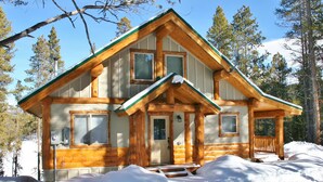 A log cabin with a green roof, wooden exterior, and a porch. - Bear's Den-Pet Friendly! Close to Ski Cooper.  Private lake access! (Leadville)