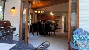 An outdoor patio area with a dining table and chairs, a grill, and a blue Adirondack chair. - Expansive Secluded Retreat w/ Hot tub, Mtn Views, 2mi to town, trails, birding (Leavenworth)