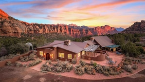 A rustic mountain lodge with a patio and a large fireplace, surrounded by rocky terrain and sparse vegetation. - Zion Villa/True North:Actually Located in & Surrounded by ZionNP Secluded10Acres (Virgin)