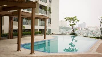 Une piscine sur le toit, agrémentée d’une pergola en bois, et offrant une vue panoramique sur la ville.