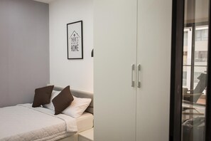 A modern bedroom with a bed, a wardrobe, and a framed quote on the wall. - Nice Apartment at GoldView (Ho Chi Minh City)