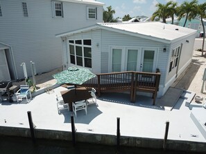 A small, single-story house with a covered patio area. - Waterfront 80' heated pool hottub Gorgeous views 20 mins to Key West & Marathon  (Cudjoe Key)