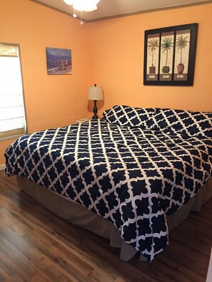 A bedroom with a bed, a lamp, and a framed picture on the wall. - Waterfront 80' heated pool hottub Gorgeous views 20 mins to Key West & Marathon  (Cudjoe Key)