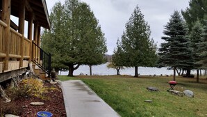 Une terrasse en bois avec un chemin en béton menant à une maison.