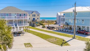 Un quartier résidentiel situé sur la côte, avec des immeubles à plusieurs étages, un ciel dégagé et une plage visible à l’arrière-plan.